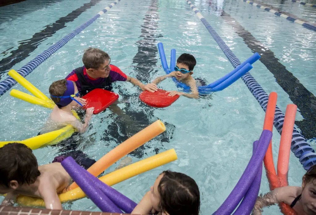 Kids in pool learning to swim