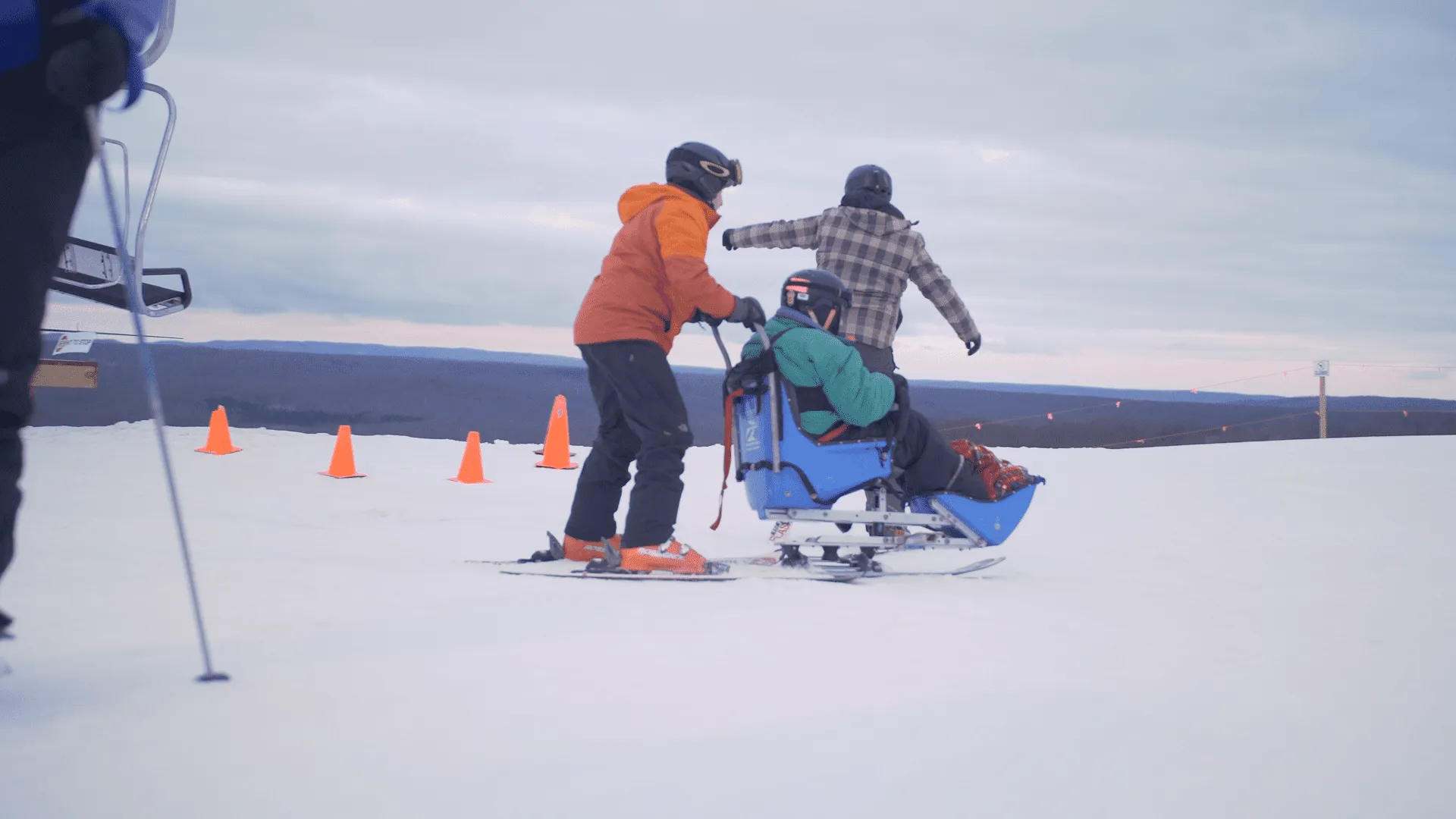 2 people helping disabled person ski