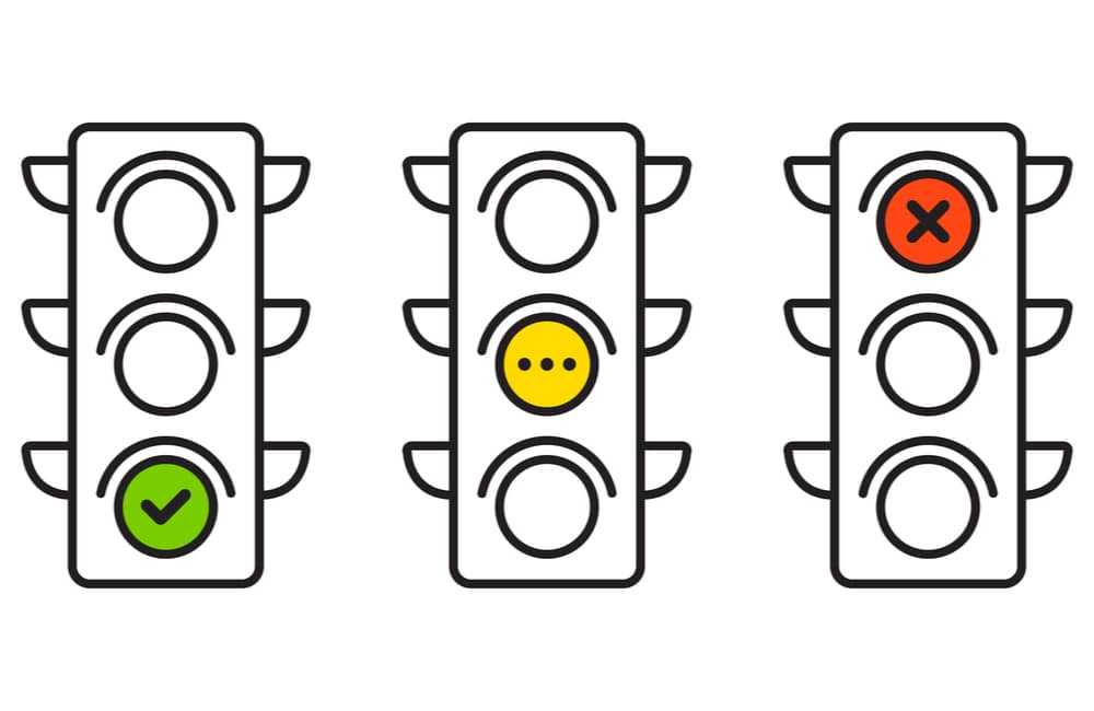 Three traffic lights one has green light, one yellow and one red.