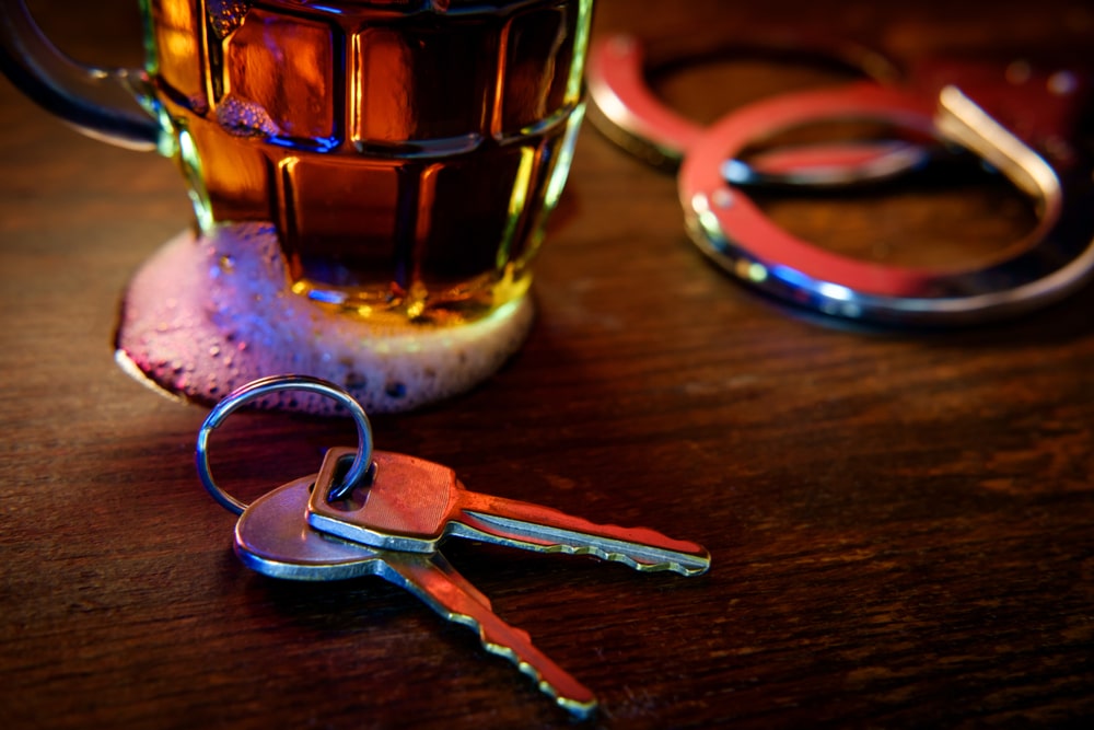 Mug Of Frothy Beer With Handcuffs And Keys Symbolizing Drunk