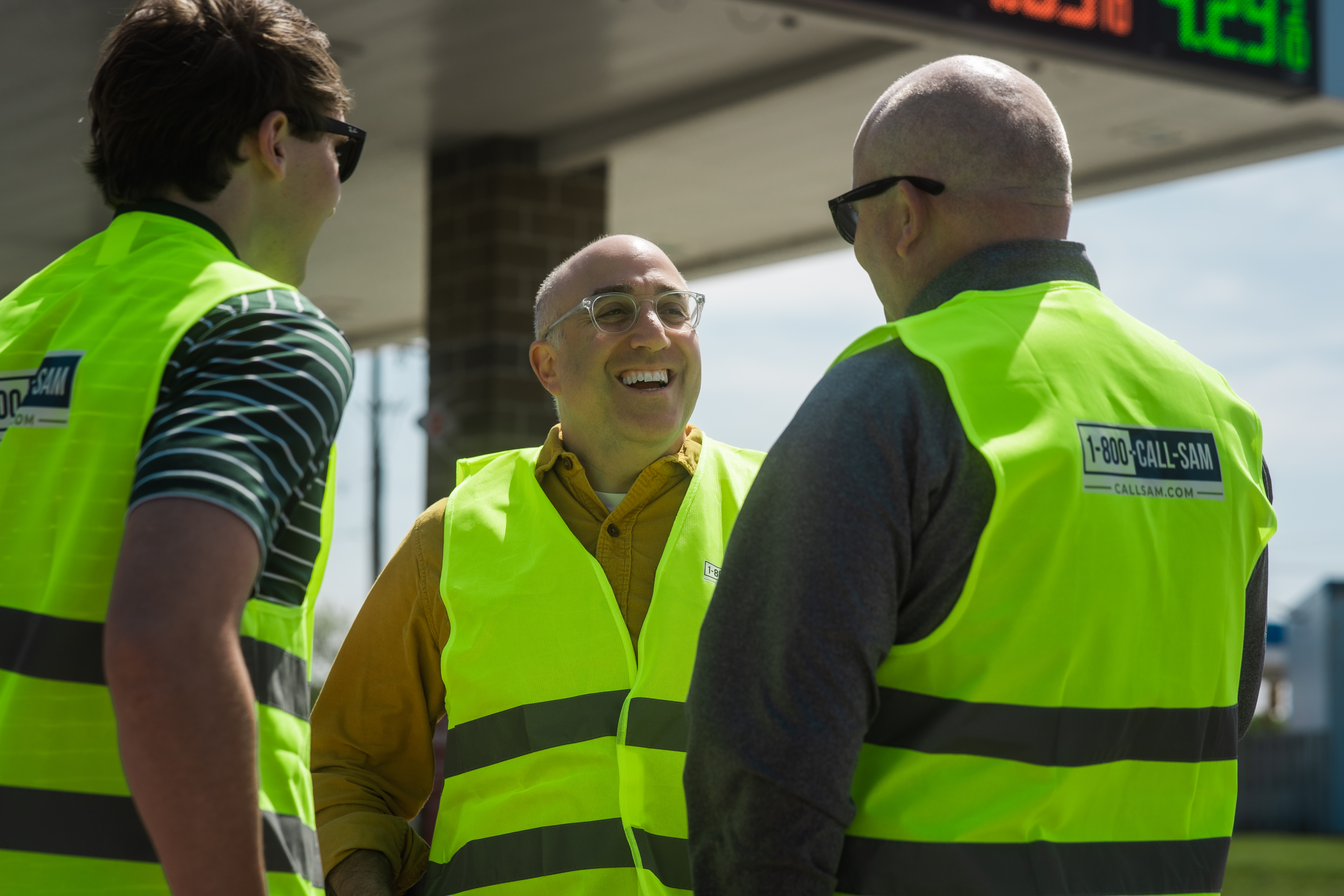 Mark Bernstein talking to another volunteer wearing high visual safety vests that read 1-800-CALL-SAM on the back of them