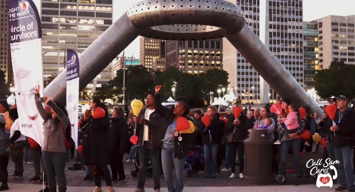 group of people garhered under statue in Campus Martius of Detroit Michigan