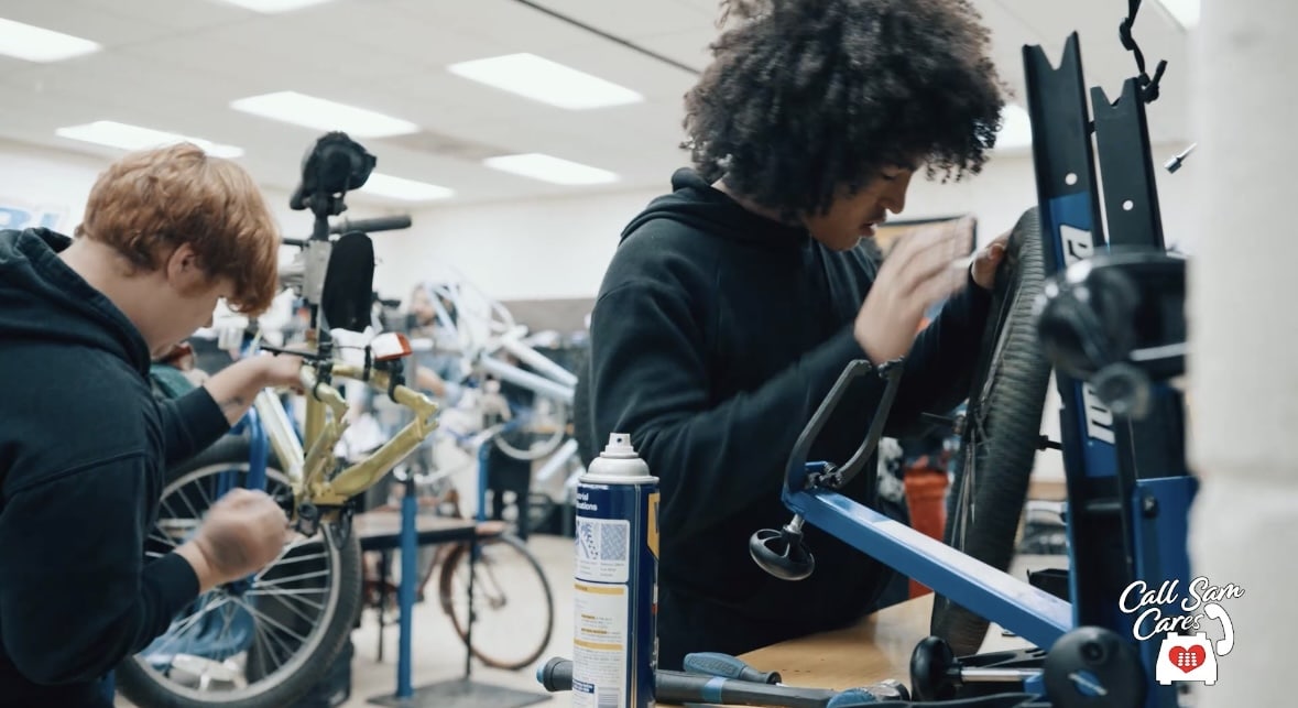 two highschool students reparing bicycles