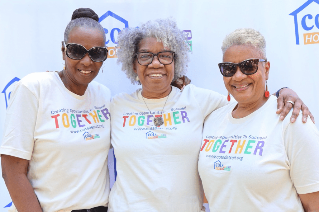 3 women standing with arms around each other