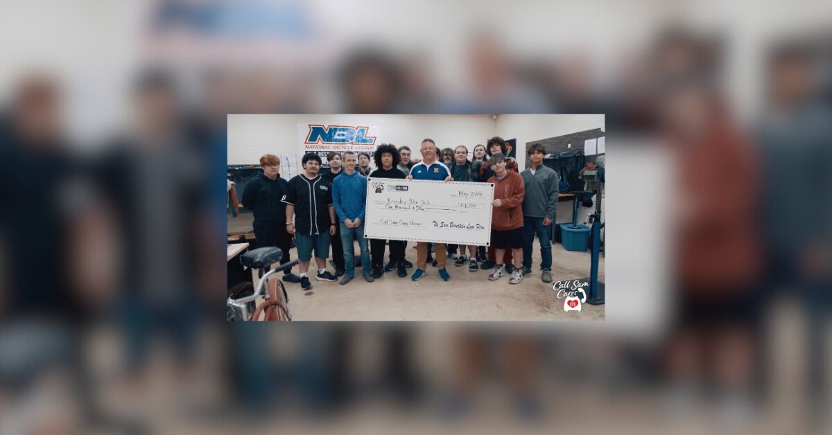 bike tech team holding large check