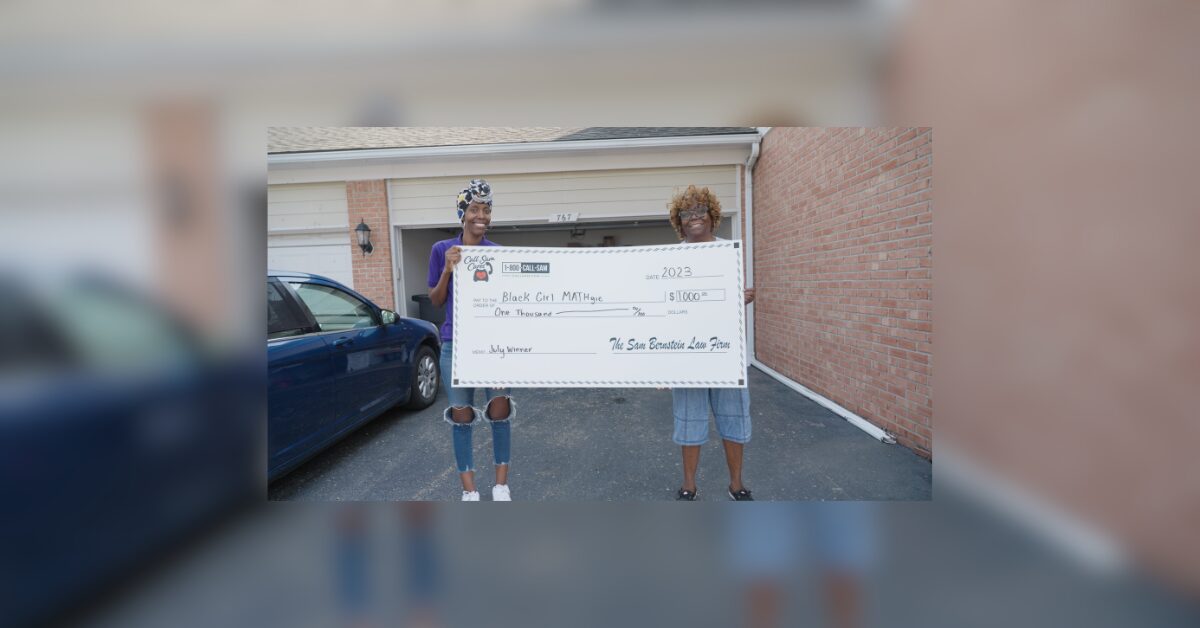 2 women holding large check
