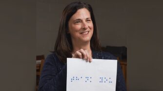 woman holding braille sign