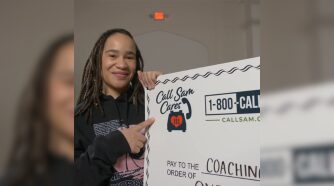 Girl pointing to Sam Cares check