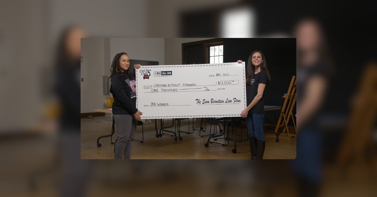 2 women holding large format check