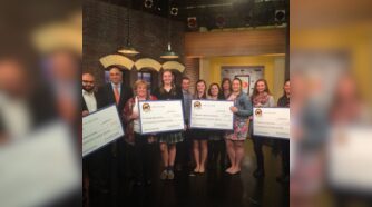 Group standing at Distraction Free event holding large certificates