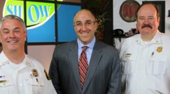 Mark Bernstein standing in between 2 men in police uniforms
