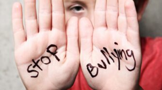Kid with hands up and written on one is the word "stop" and "bullying" on the other